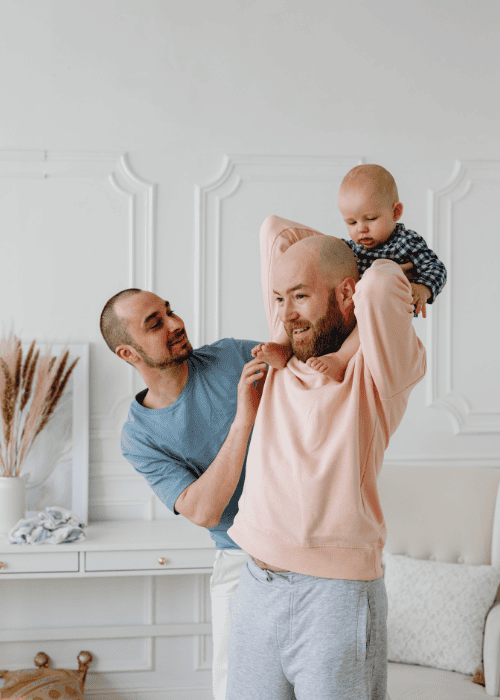 Two men with their baby receiving LGBTQ+ mental health care