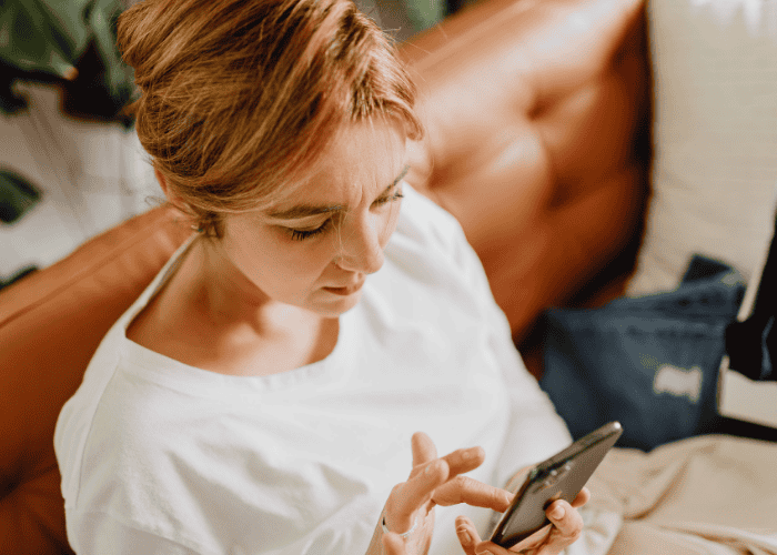 woman looking at phone needing ways to manage information overload in the news and social media