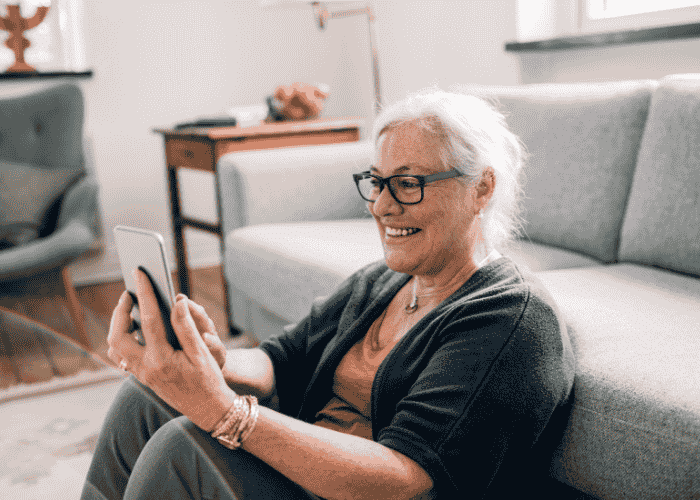 Woman smiling using phone for social media after support with managing social media algorithms’ impact on mental health