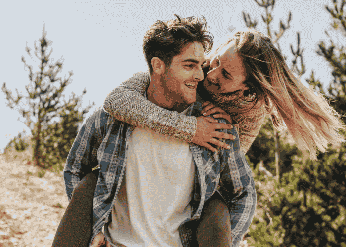 Couple outside for a walk smiling after support with Can AI replace real-life relationships?