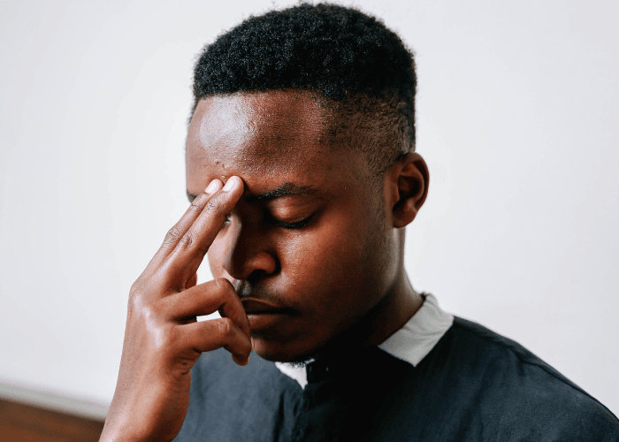 Man looking worried with hand on head due to needing affordable mental health care