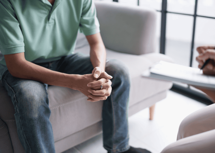 Man in therapy session sitting on sofa wondering how to make the most out of mental health appointments