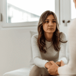 Woman sitting sofa talking to mental health expert seeking support with navigating California mental health system under new laws