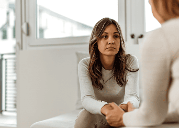 Woman sitting sofa talking to mental health expert seeking support with navigating California mental health system under new laws