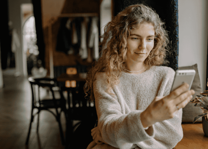 Woman looking at phone wanting support with how to use mental health apps wisely
