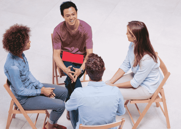 Man in group therapy session smiling after seeking early intervention mental health care