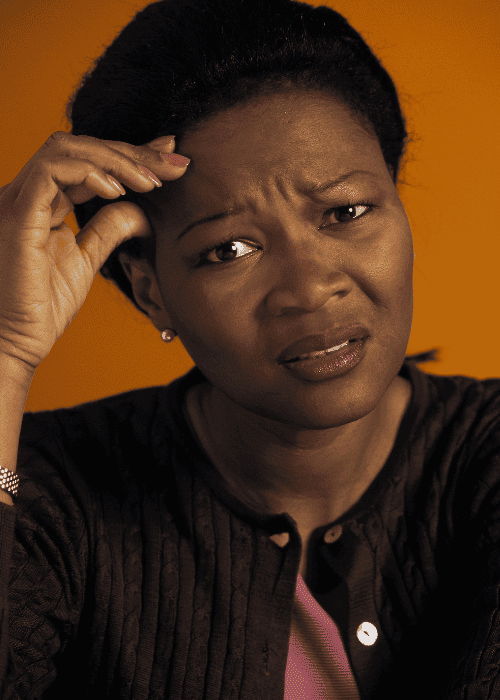 Woman looking distressed with her hands on her head, wondering how cognitive distortions shape thinking and behavior