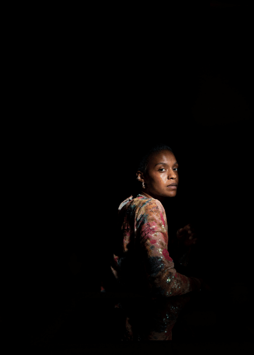 Woman in pitch black with light shining on her face, showing experience of trauma and cognitive distortions