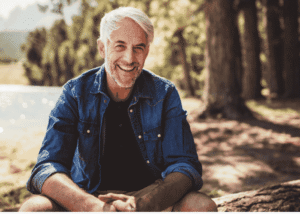Man sitting outdoors smiling and happy after receiving treatment for cognitive distortions in ocd