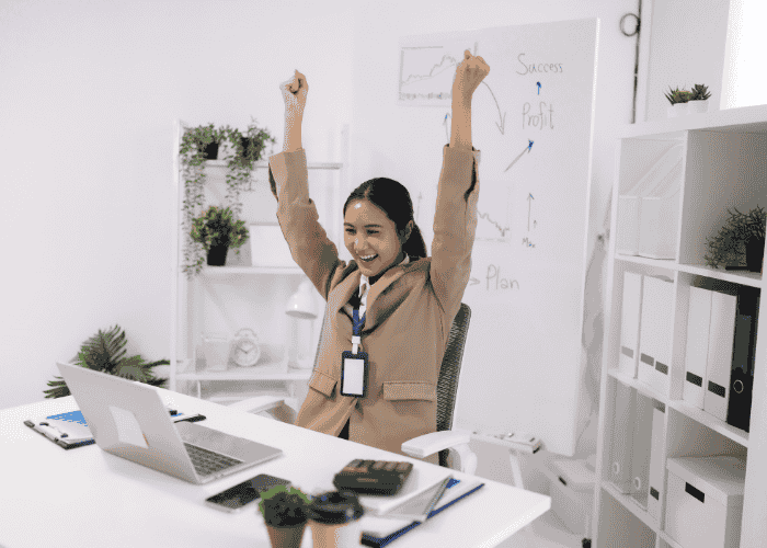 Woman celebrating at work after learning how cognitive distortions lead to burnout