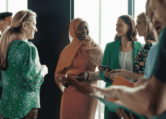 Group of people from different communities smiling and chatting after learning about marginalized communities and mental health care