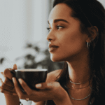 Woman drinking coffee looking calm after support with people pleasing