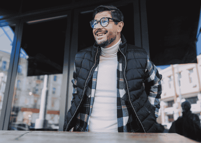 Man standing outside office block smiling after receiving support for chronic fatigue syndrome