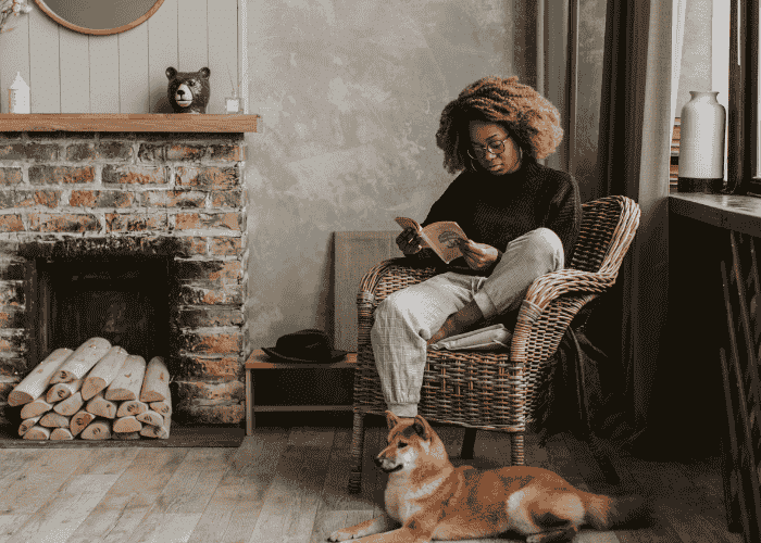 Woman sitting in armchair reading a book relaxing after support with experiencing headline stress disorder