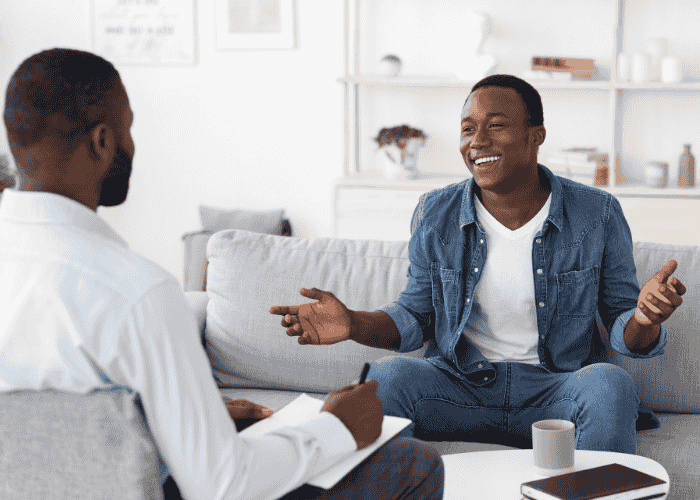 Man sitting on couch in therapy session after finding out how professionals refer patients to outpatient mental health care