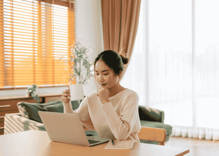 Woman sitting at desk looking calm after accessing telehealth mental health services for employees