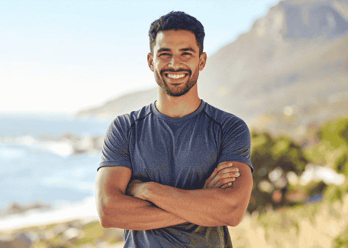 Man standing outside smiling with arms crossed after support witih IBS and mental health