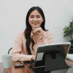 Woman sitting at desk smiling after seeking support for high-functioning depression