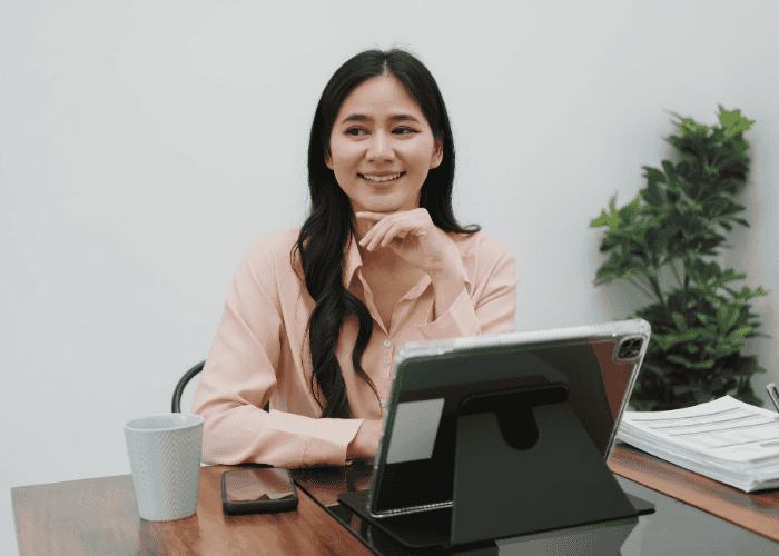 Woman sitting at desk smiling after seeking support for high-functioning depression