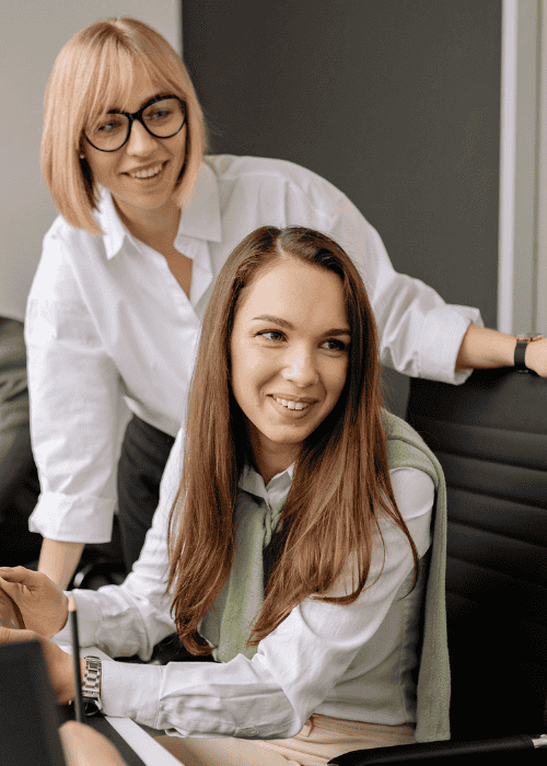 Man sitting at desk covered in paperwork looking overwhelmed with hands over face