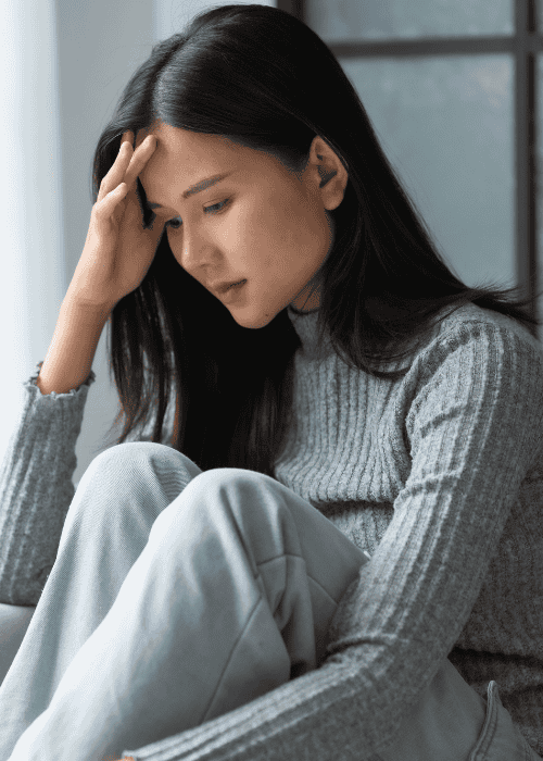 Woman sitting at home on sofa needing support with return-to-work planning after mental health treatment