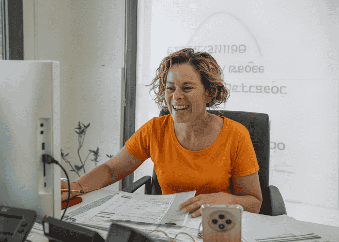 Woman smiling at work after understanding when work stress requires clinical intervention
