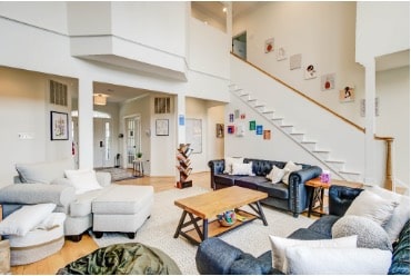 Welcoming common area at a Mission Connection location with soft seating arranged for conversation, high ceilings, and curated artwork.