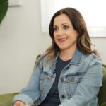 Woman smiling and sitting on green couch during therapy session