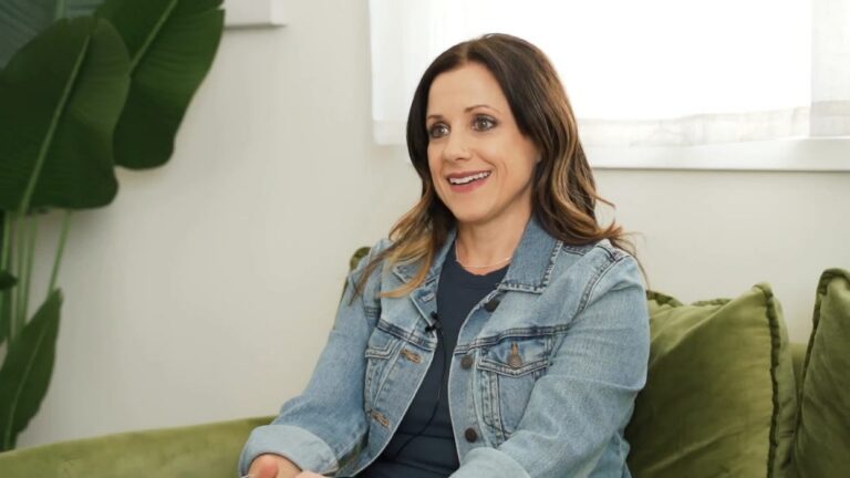 Woman smiling and sitting on green couch during therapy session