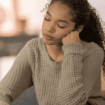 Woman sitting with head on hand with her eyes closed worrying about neurogenesis and antidepressants