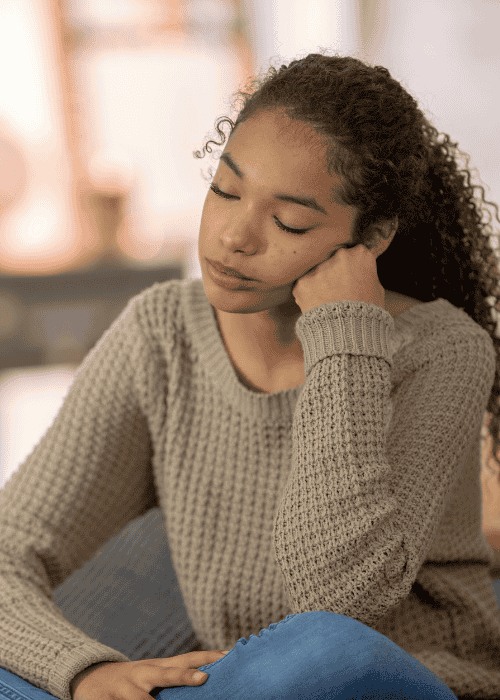 Woman sitting with head on hand with her eyes closed worrying about neurogenesis and antidepressants