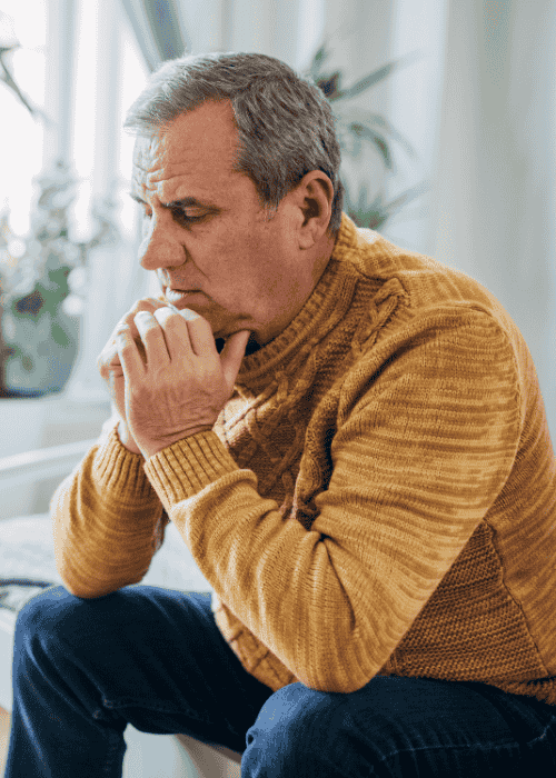 Man sitting on edge of bed worrying about genetics and mental health risk
