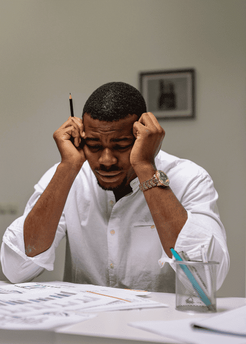 Man sitting at desk with head in hands needing support with blood sugar and anxiety