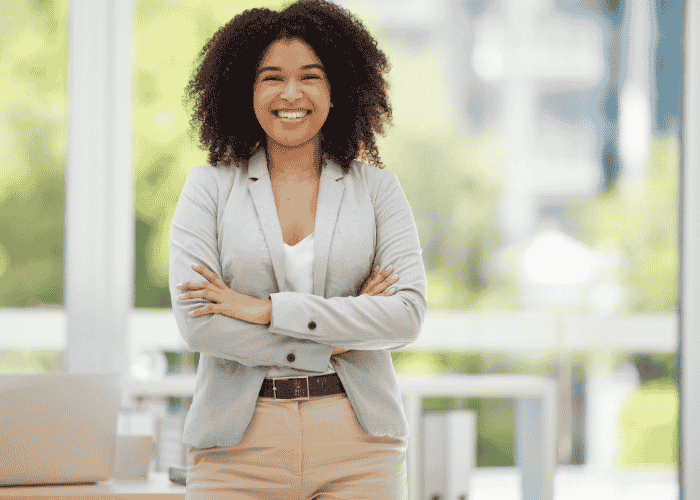 Woman standing with arms crossed smiling after support with genetics and mental health risk