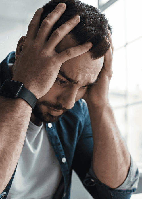 Man with head in hands needing support with breathwork for mental health
