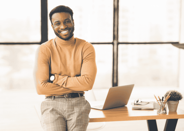Man sitting on desk with arms folded smiling after support with Single Case Agreements