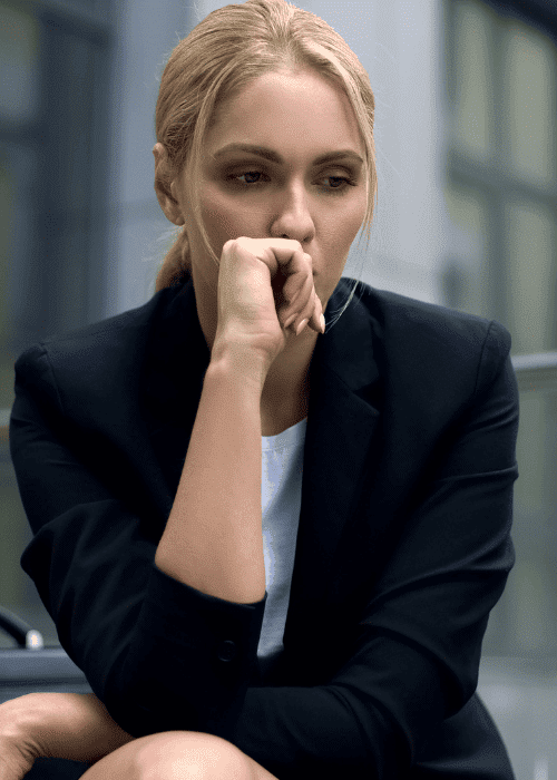 Woman sitting outside office building on step representing amygdala and stress responses