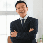 Man standing in office with arms folded smiling after support with anxiety and the amygdala