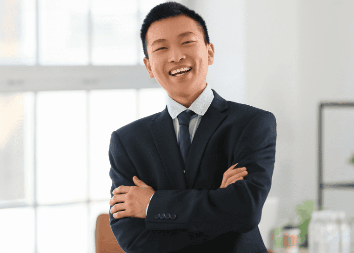 Man standing in office with arms folded smiling after support with anxiety and the amygdala