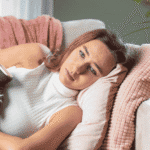 Woman laying on couch needing support with hormonal cycles and depression