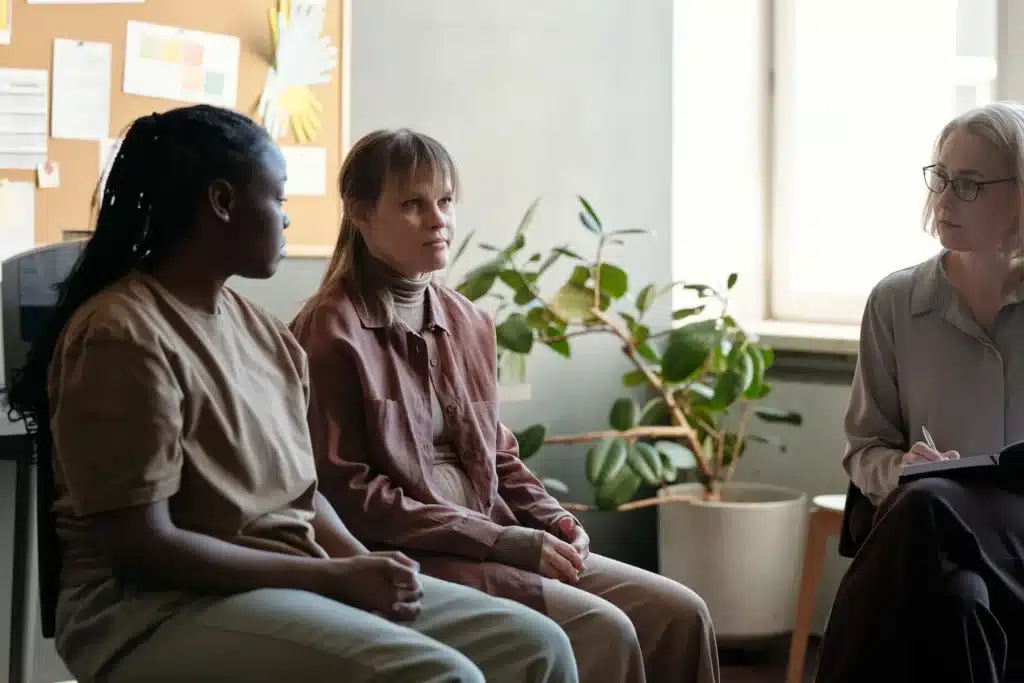 woman in group therapy sitting in an office with a therapist