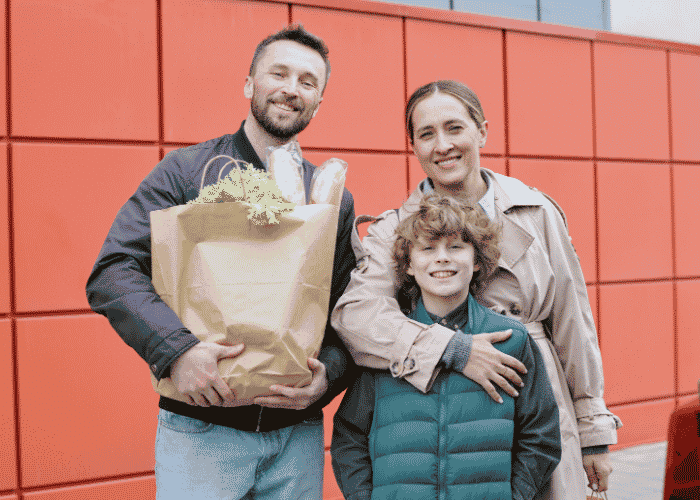 Woman standing in street with her husband and son smiling after support with the stress response system
