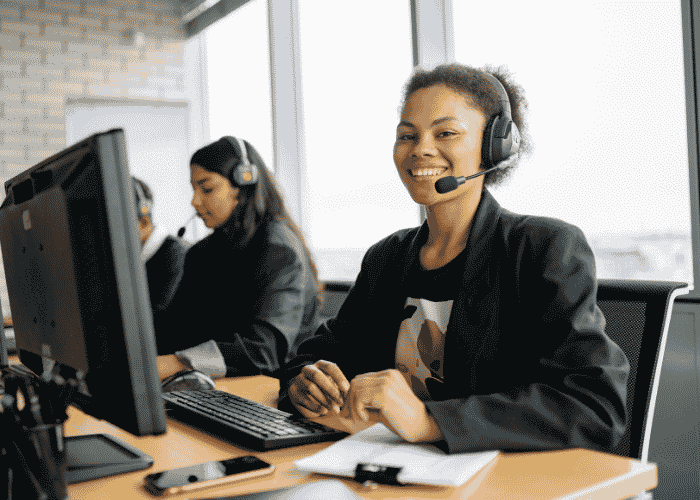 Woman working in call centre smiling after support with brain fog and cognitive impairment