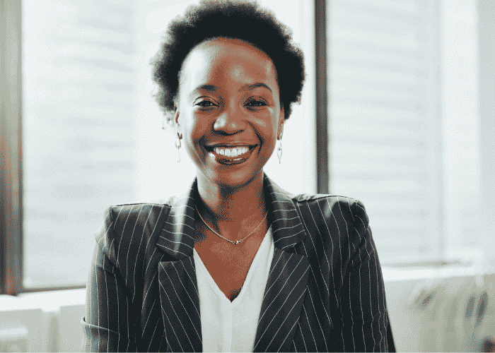 Woman working in office smiling after support with how trauma affects the nervous system